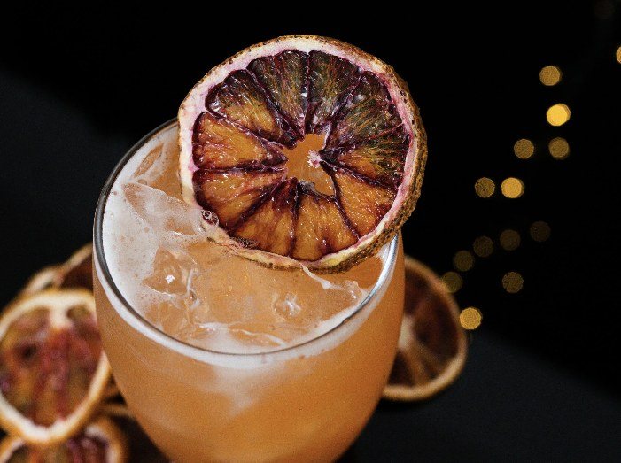 Cocktail garnished with a dried blood orange slice
