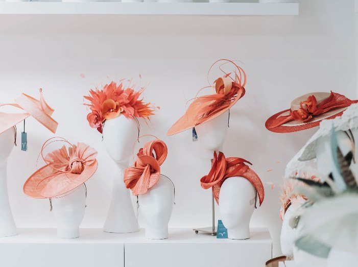 Coral and peach couture hats on mannequin heads