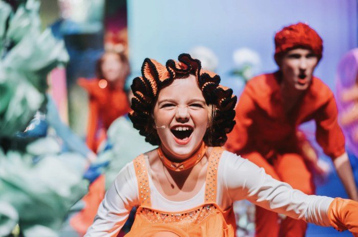 Young performer mid-song on stage